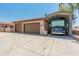 Spacious three-car garage with an RV parking space under a metal awning, perfect for vehicle storage at 7425 W Caro Rd, Glendale, AZ 85308