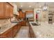 Spacious kitchen featuring granite countertops, wood cabinets, stainless steel appliances, and pendant lighting at 7425 W Caro Rd, Glendale, AZ 85308