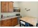 This kitchenette has wooden cabinets, granite countertops, stainless steel appliances, and a table with a butcher block top at 7425 W Caro Rd, Glendale, AZ 85308