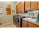 Well-organized laundry room with modern washer and dryer, granite countertop, sink, and ample cabinet space at 7425 W Caro Rd, Glendale, AZ 85308