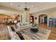 Open-concept living room with hardwood floors, a ceiling fan, and seamless flow into the kitchen and dining areas at 7425 W Caro Rd, Glendale, AZ 85308