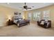 Spacious bedroom boasts plush carpeting, ceiling fan, plantation shutters, and a cozy leather couch at 7425 W Caro Rd, Glendale, AZ 85308
