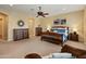 Large bedroom features a wood bed and dressers, carpet flooring, and a ceiling fan at 7425 W Caro Rd, Glendale, AZ 85308