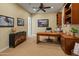 Home office featuring custom built-ins, ample natural light, and a ceiling fan at 7425 W Caro Rd, Glendale, AZ 85308