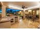 Outdoor kitchen and bar area with a built-in grill, mini-fridge, and sink with a view of the backyard at 7425 W Caro Rd, Glendale, AZ 85308