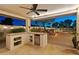Outdoor kitchen with a sink, mini fridge, and views of the garden, outdoor seating and a pool at 7425 W Caro Rd, Glendale, AZ 85308