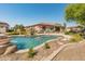 Beautiful backyard pool with waterfall features surrounded by desert landscaping and seating at 7425 W Caro Rd, Glendale, AZ 85308