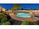 Backyard pool with a fire feature and a poolside bar surrounded by desert landscaping at 7425 W Caro Rd, Glendale, AZ 85308