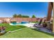Relaxing backyard oasis featuring a beautiful pool with rock slide, comfortable seating, and lush artificial grass at 8418 W Palmaire Ave, Glendale, AZ 85305