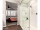 A glass shower with white surround stands adjacent to a bedroom in this home at 8418 W Palmaire Ave, Glendale, AZ 85305