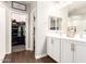 A well lit bathroom with double sinks, white cabinets and a walk-in closet at 8418 W Palmaire Ave, Glendale, AZ 85305
