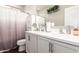 This bathroom features double sinks, white cabinets, and plants on the shelves, all contributing to an elegant look at 8418 W Palmaire Ave, Glendale, AZ 85305