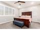 A primary bedroom features a ceiling fan, gray walls, and a large window for natural light at 8418 W Palmaire Ave, Glendale, AZ 85305