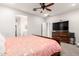 A primary bedroom showcases a ceiling fan, and a large TV over a wooden dresser at 8418 W Palmaire Ave, Glendale, AZ 85305