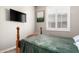 Modernly designed bedroom featuring a wall-mounted television and a sunlit window at 8418 W Palmaire Ave, Glendale, AZ 85305