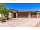 Beautiful single-story home showcasing a three-car garage and desert landscaping on a sunny day at 8418 W Palmaire Ave, Glendale, AZ 85305