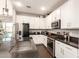 Open kitchen featuring white cabinetry, stainless steel appliances, and dark countertops, plus a view to the yard at 8418 W Palmaire Ave, Glendale, AZ 85305