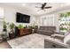 Inviting living room with plush seating, a large television, stylish ceiling fan, and plenty of plants at 8418 W Palmaire Ave, Glendale, AZ 85305