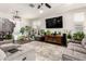 Spacious living room featuring comfortable seating, a large TV, and an array of indoor plants at 8418 W Palmaire Ave, Glendale, AZ 85305