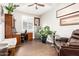 A spacious office area featuring tile floors, a wooden desk, a safe, and comfortable seating at 8418 W Palmaire Ave, Glendale, AZ 85305