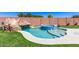 Stunning backyard pool area featuring a rock slide, spa, and lush green artificial grass at 8418 W Palmaire Ave, Glendale, AZ 85305