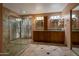Bathroom with stone-tile shower, wood cabinets, dual vanity with round mirrors at 8637 E Appaloosa Trl, Scottsdale, AZ 85258