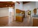 Open living room and kitchen featuring vaulted wood-beam ceilings, laminate flooring, and fireplace at 8637 E Appaloosa Trl, Scottsdale, AZ 85258