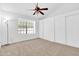 Bright bedroom featuring neutral carpet, a ceiling fan, a window and closet with sliding doors at 921 W University Dr # 1023, Mesa, AZ 85201