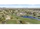 Expansive aerial view of the community featuring a golf course, clubhouse, lush landscaping, and scenic mountain views at 9826 W Tonto Ln, Peoria, AZ 85382