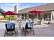 Backyard features multiple seating areas, red umbrellas, and pavers, creating a versatile outdoor space at 9826 W Tonto Ln, Peoria, AZ 85382