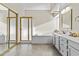 A well-lit bathroom features a large tub, shower, and a vanity with sink at 9826 W Tonto Ln, Peoria, AZ 85382