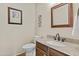 Half-bathroom featuring a wood vanity with granite countertop, mirror, and toilet with wood-look floors at 9826 W Tonto Ln, Peoria, AZ 85382