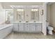 Bright bathroom with a double vanity, large mirrors, and separate tub and toilet at 9826 W Tonto Ln, Peoria, AZ 85382