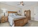 Comfortable bedroom boasts natural wood furniture, ceiling fan and neutral decor, creating a relaxed atmosphere at 9826 W Tonto Ln, Peoria, AZ 85382