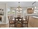 Bright dining room with large bay windows and wooden table with seating for eight at 9826 W Tonto Ln, Peoria, AZ 85382
