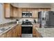 This kitchen features wooden cabinets, stainless steel appliances, and granite countertops at 9826 W Tonto Ln, Peoria, AZ 85382