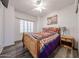 Cozy bedroom features a brightly colored bed set, ceiling fan, and wood-look flooring at 10832 W Piute Ave, Peoria, AZ 85373