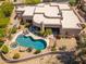 Stunning aerial view of the property showcasing the house, pool, landscaping, and surrounding desert landscape at 10901 E Quarry E Trl, Scottsdale, AZ 85262