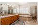Bathroom features double sinks, and a shower, with a soaking tub under shuttered windows at 10901 E Quarry E Trl, Scottsdale, AZ 85262