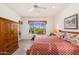 Bedroom features carpet, a ceiling fan and a large window overlooking a lush backyard at 10901 E Quarry E Trl, Scottsdale, AZ 85262