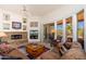 Comfortable living room features a stone fireplace, beamed ceiling, and patio access at 10901 E Quarry E Trl, Scottsdale, AZ 85262