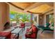 Inviting covered patio featuring a fireplace, ample seating, and serene outdoor views at 10901 E Quarry E Trl, Scottsdale, AZ 85262