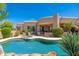 Backyard pool with rock features, lush desert landscaping, and comfortable lounge chairs at 10901 E Quarry E Trl, Scottsdale, AZ 85262