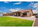 A large backyard with green grass, brick patio, shed, and outdoor furniture at 11133 E Dragoon Ave, Mesa, AZ 85208