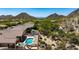 Stunning aerial view showcases a backyard pool, spa, and lush desert landscape against a mountain backdrop at 11856 E Parkview Ln, Scottsdale, AZ 85255