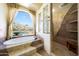 Well-lit bathroom features a relaxing soaking tub, a walk-in glass shower, and scenic outdoor views at 11856 E Parkview Ln, Scottsdale, AZ 85255