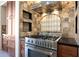 Kitchen showcases stainless steel range with custom vent hood and tiled backsplash with beautiful wood cabinets at 11856 E Parkview Ln, Scottsdale, AZ 85255