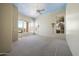 Large living room with carpet floors, a ceiling fan, and large windows that provide natural light at 11856 E Parkview Ln, Scottsdale, AZ 85255