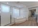 Bathroom featuring soaking tub and glass shower adjacent to hardwood floors and fireplace at 13305 W Colter St, Litchfield Park, AZ 85340