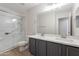 Modern bathroom featuring a double sink vanity, large mirror, and glass-enclosed shower at 13305 W Colter St, Litchfield Park, AZ 85340
